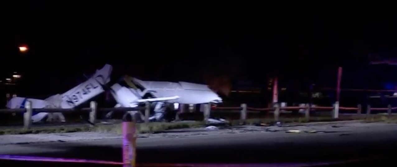 Nighttime scene of wrecked Orlican M-8 Eagle plane with tail number N974FL crashed near Lake Osborne Drive in Lake Worth Beach, Florida, after colliding with a vehicle.